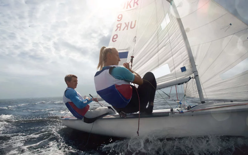 Zdjęcie dwóch osób żeglujących - męszczyzna i kobieta w kapokach